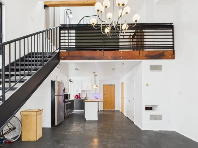 Staircase featuring a high ceiling and finished concrete flooring
