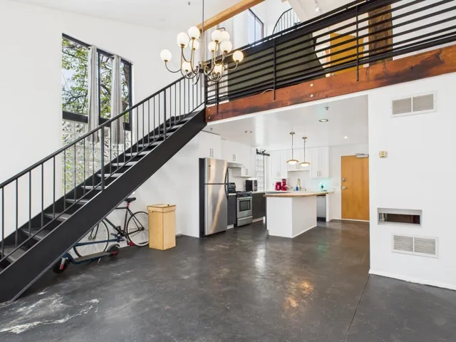 Unfurnished living room with finished concrete floors, a high ceiling, and plenty of natural light