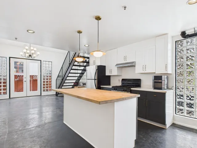 Kitchen featuring white cabinetry, finished concrete flooring, recessed lighting, a kitchen island, and freestanding refrigerator