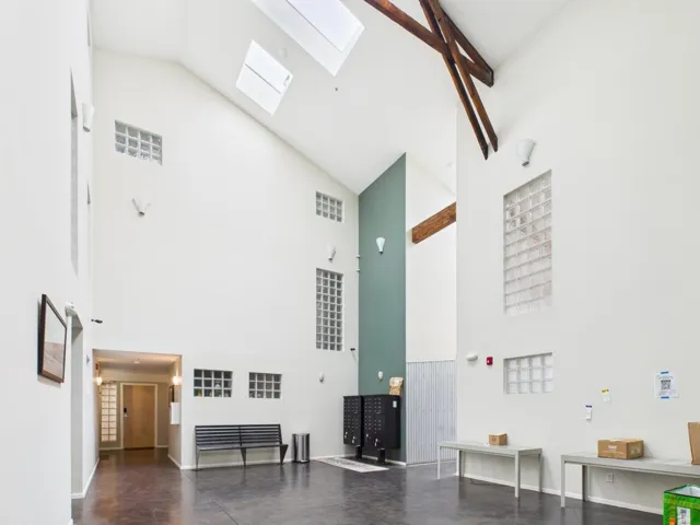 Miscellaneous room featuring a skylight and high vaulted ceiling