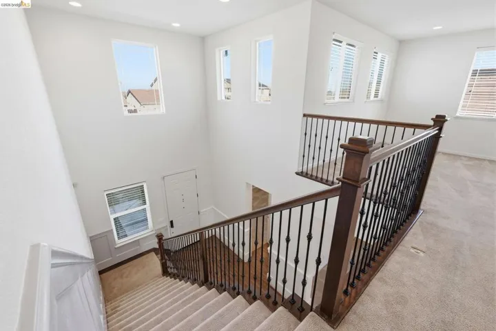 Stairway with carpet flooring and recessed lighting