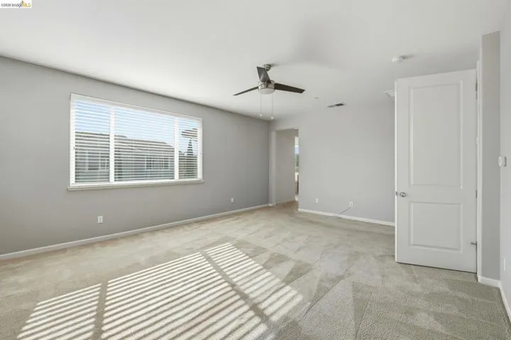 Spare room with light colored carpet and ceiling fan