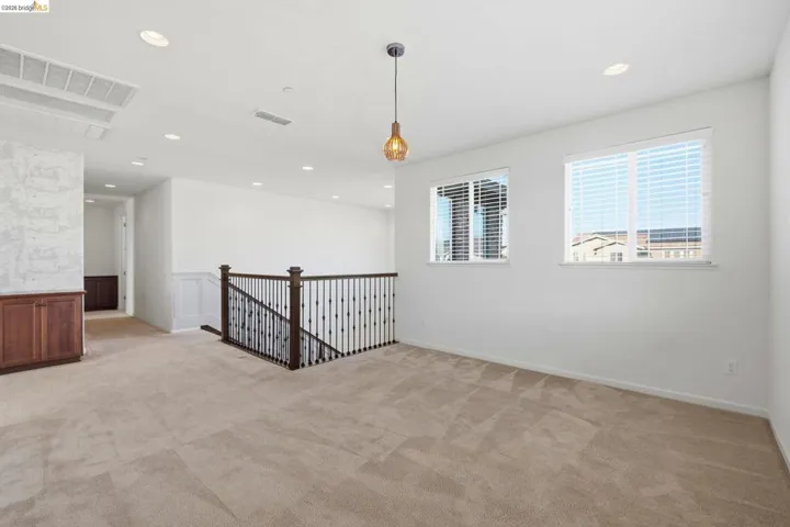 Spare room with a wainscoted wall, light carpet, recessed lighting, and a decorative wall