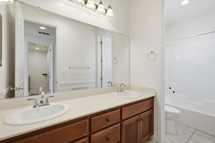 Full bathroom with recessed lighting, double vanity, and tub / shower combination