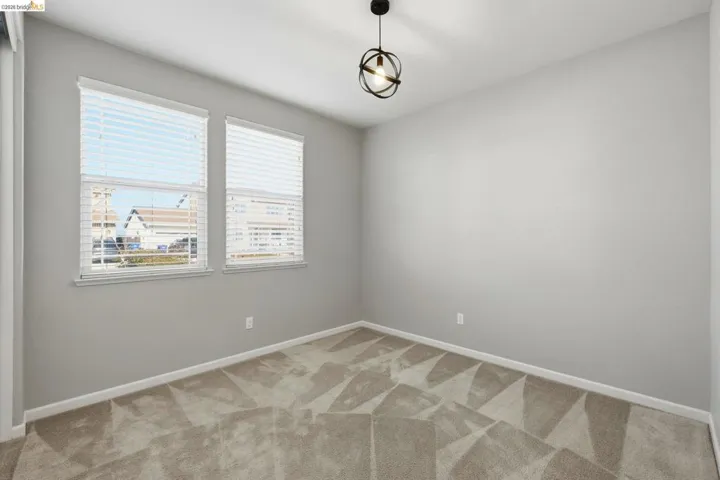 Carpeted spare room with baseboards