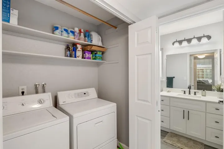 Laundry area with washer and dryer and wood finished floors