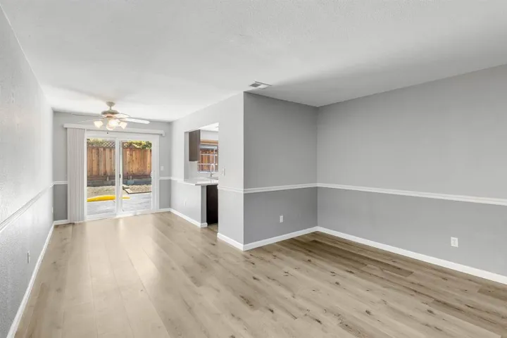 Unfurnished living room featuring a ceiling fan and light wood-style flooring
