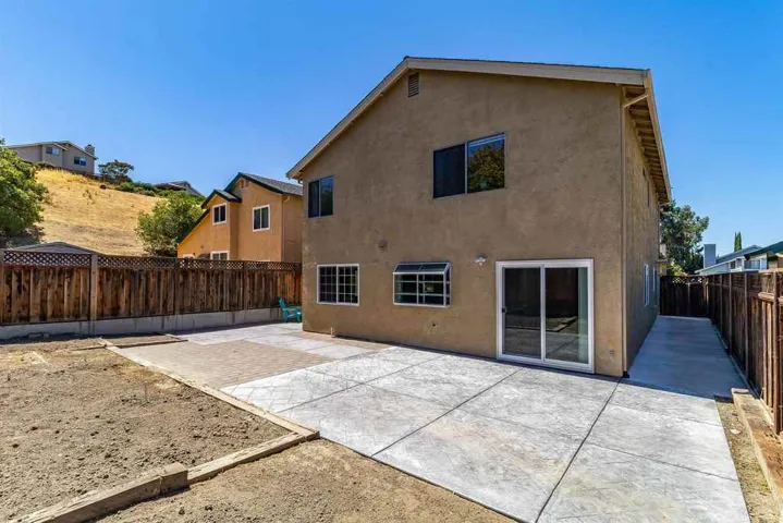 Back of house featuring a patio area, stucco siding, and a fenced backyard