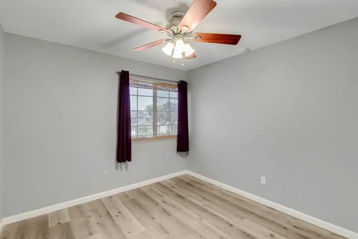 Spare room with light wood finished floors and ceiling fan