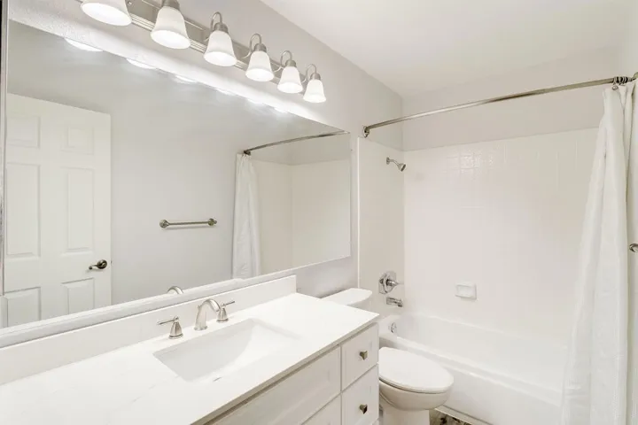Bathroom featuring shower / bath combo with shower curtain and vanity