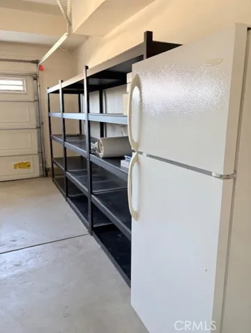 Garage with refrigerator and storage rack