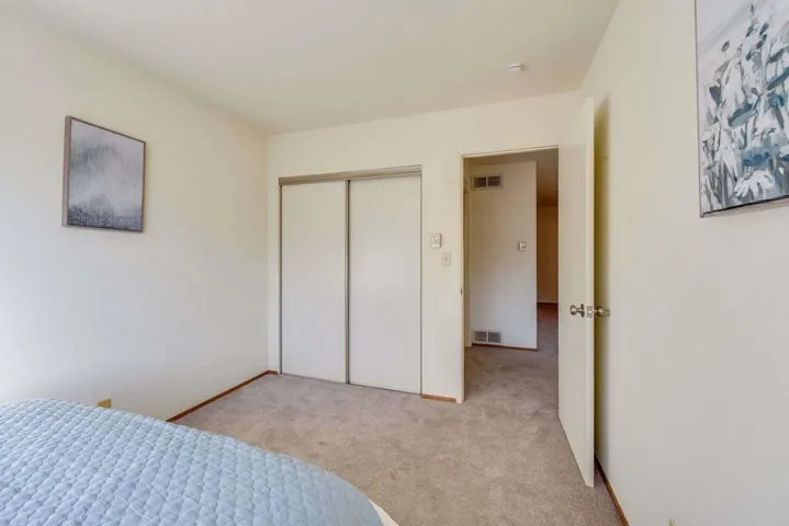 Carpeted bedroom featuring a closet