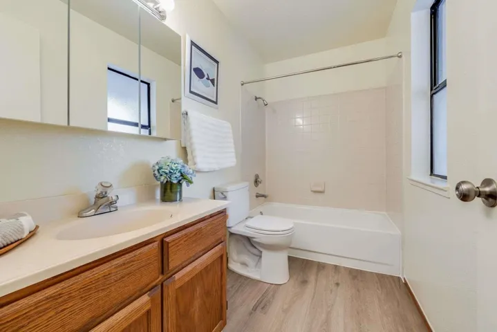 Bathroom with vanity,  shower combination, and light wood-style floors