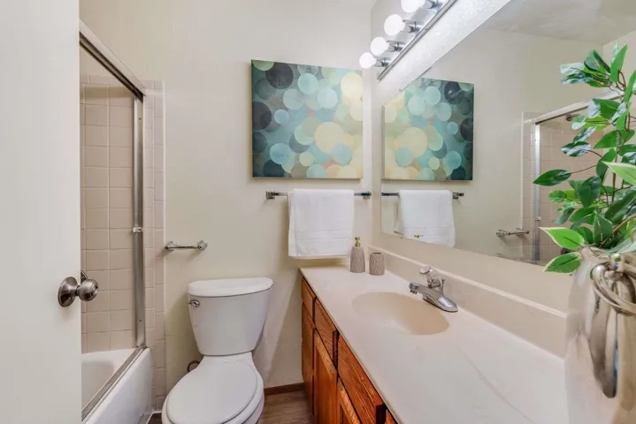 Bathroom featuring vanity and shower / bath combination with glass door