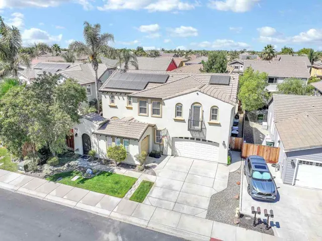 Mediterranean / spanish house featuring solar panels, stucco siding, driveway, and a residential view