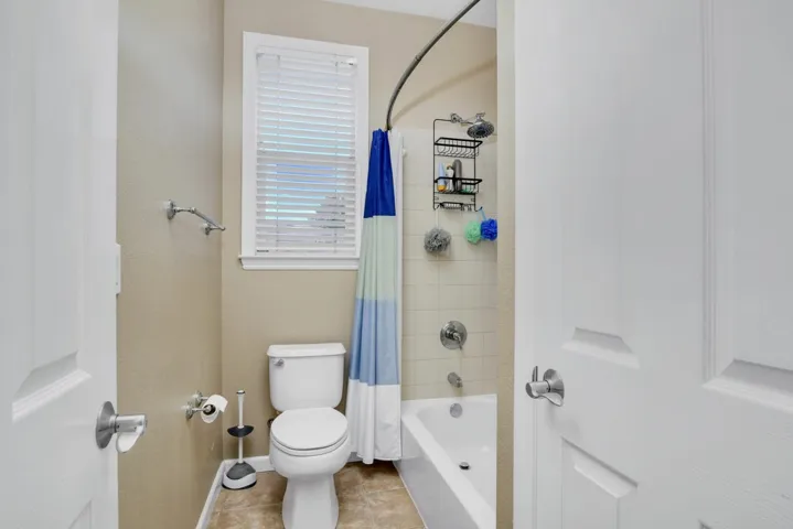 Bathroom featuring shower / bath combo and tile patterned floors
