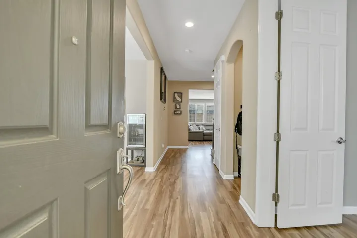 Foyer entrance featuring light wood-type flooring, arched walkways, and recessed lighting