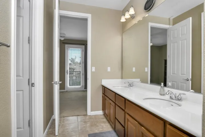 Bathroom featuring double vanity and light tile patterned floors
