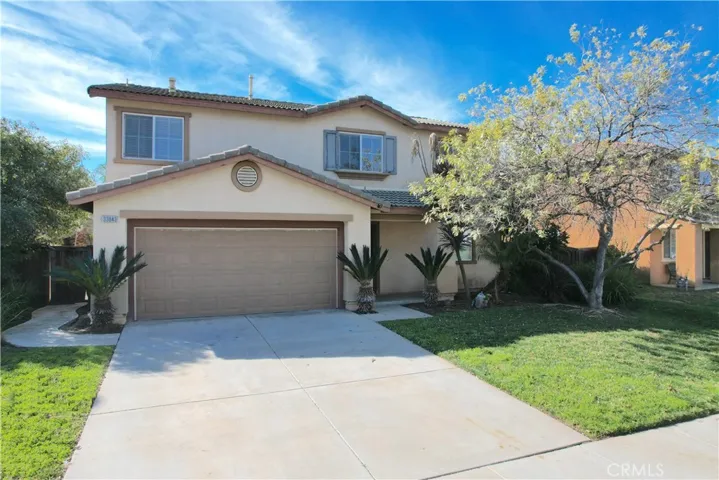 Charming Two-Story Home With Stucco Exterior, Tile Roof, And Manicured Landscaping