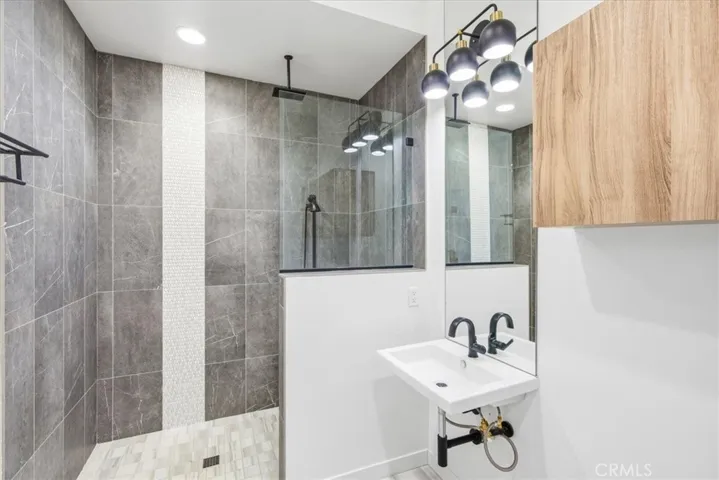Luxury bathroom with dual vanities, a walk-in shower, and earthy tones
