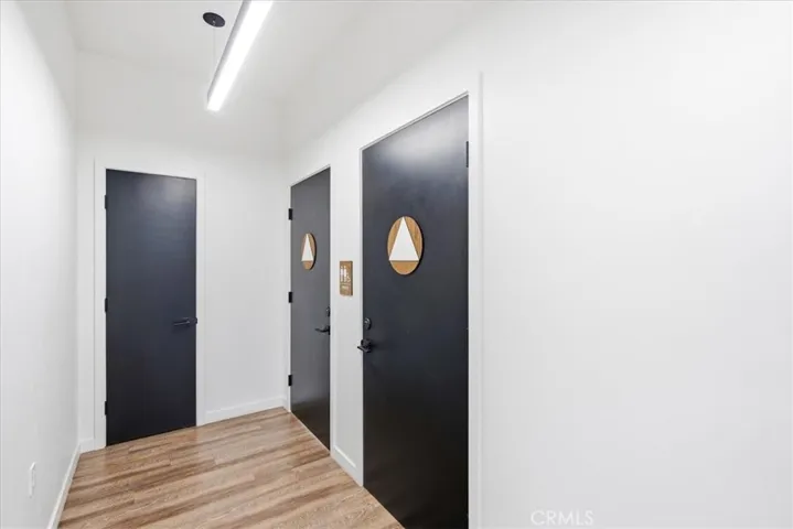 Stylish hallway with polished wood floors and modern, black-accented doors.