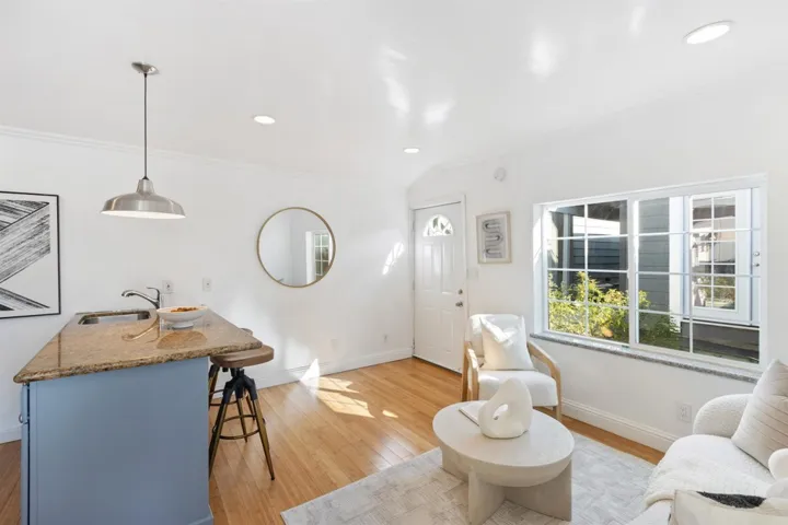 Living room featuring light wood-style flooring, recessed lighting, and crown molding