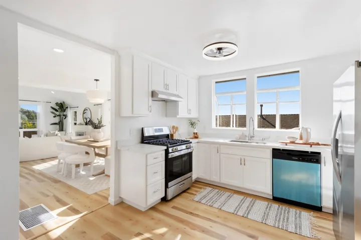 Kitchen featuring appliances with stainless steel finishes, white cabinets, recessed lighting, light wood-type flooring, and healthy amount of natural light