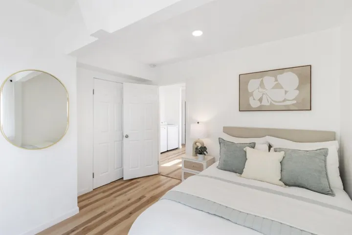 Bedroom with light wood-style floors, recessed lighting, separate washer and dryer, and a closet