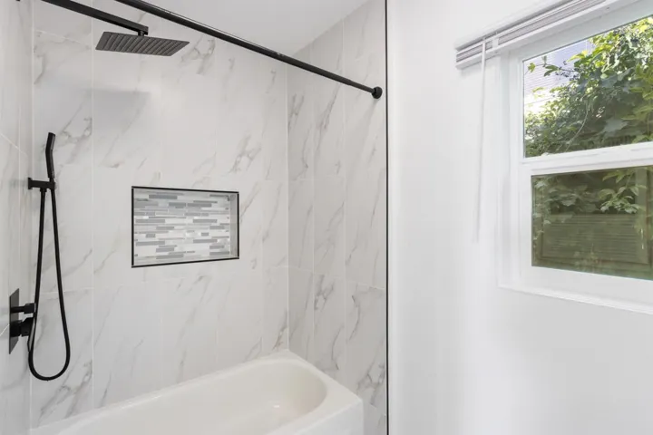 Bathroom with a combined bath / shower with marble appearance