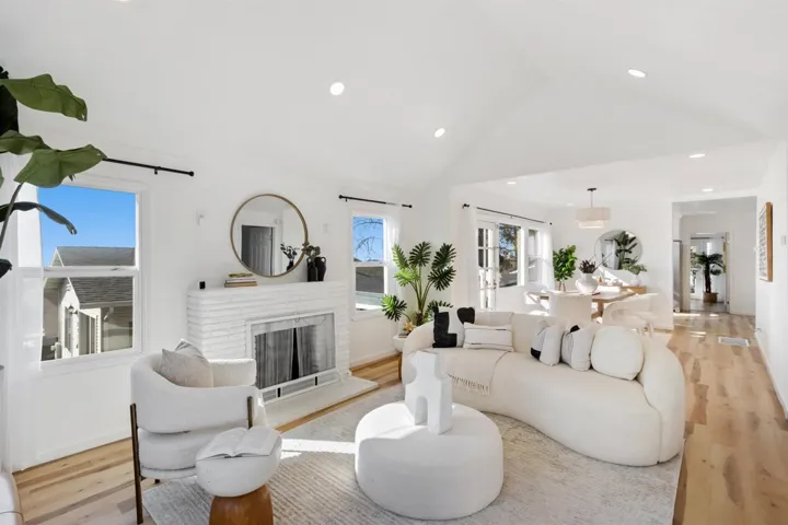 Living area featuring light wood-style floors, a brick fireplace, high vaulted ceiling, and recessed lighting