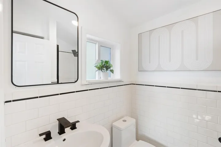 Bathroom featuring tile walls, wainscoting, and a shower