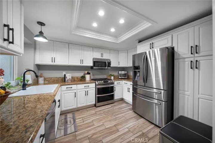 Functional Kitchen with Granite Counter top, white shaker cabinets, stainless steel appliances, and kitchen pantry.