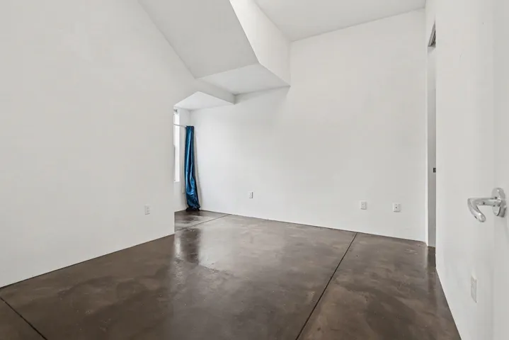 Empty room featuring finished concrete floors