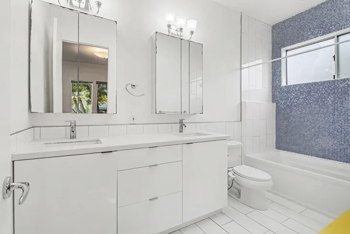 Full bathroom with plenty of natural light, double vanity, and  shower combination