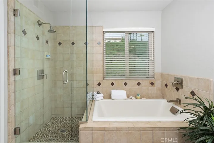 Along with a Soaking Tub and Shower, this Bathroom has a Separate Toilet Room and Large Walk-in Closet designed by Closet World!