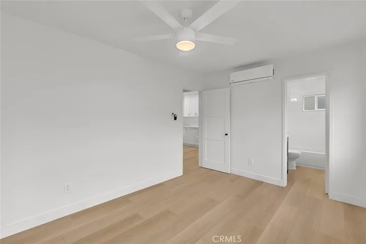 Bedroom view of the door to living room and kitchen.  Door to the bathroom.  Mini split was installed for cool air.