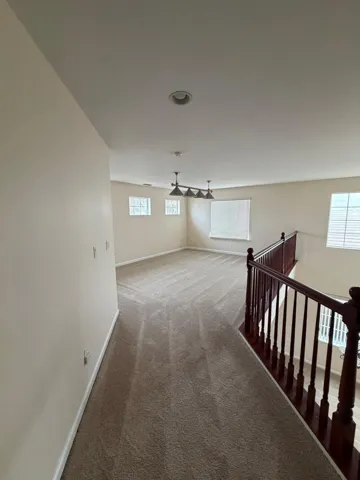 Corridor with carpet and an upstairs landing