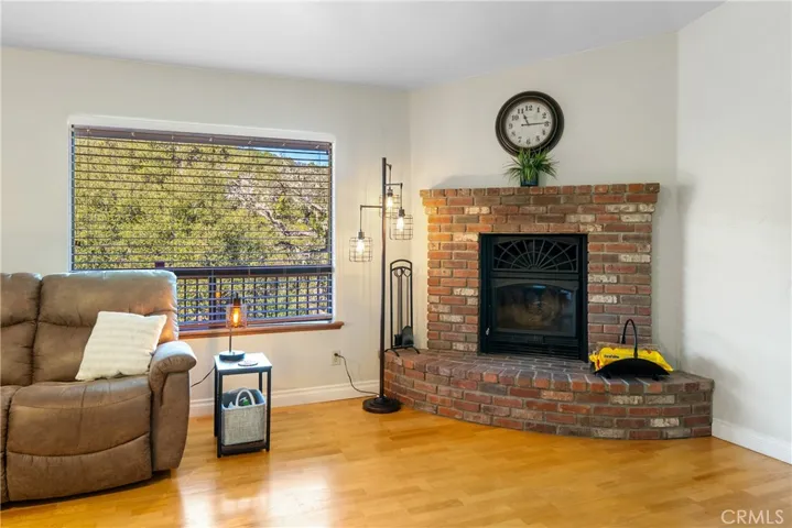 In the corner of the living room is a cozy wood burning stove with red brick surround.