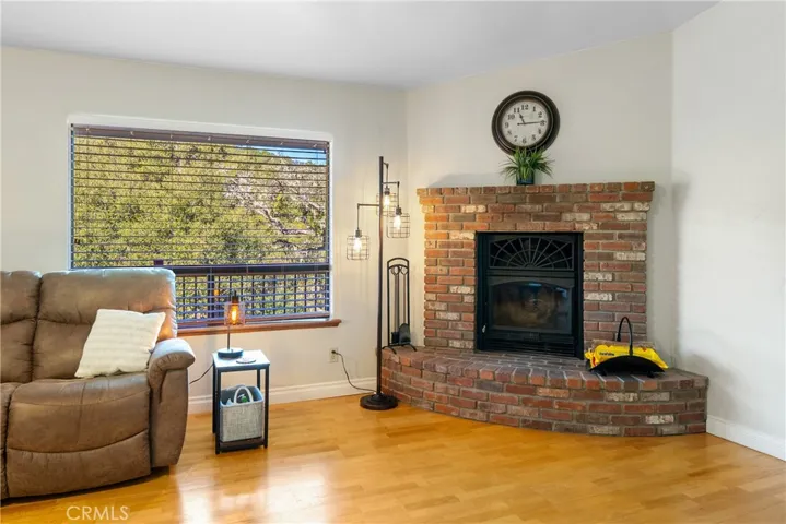 In the corner of the living room is a cozy wood burning stove with red brick surround.