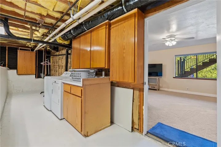 Through the door in the family room we find the laundry area complete with cabinets and a folding counter.