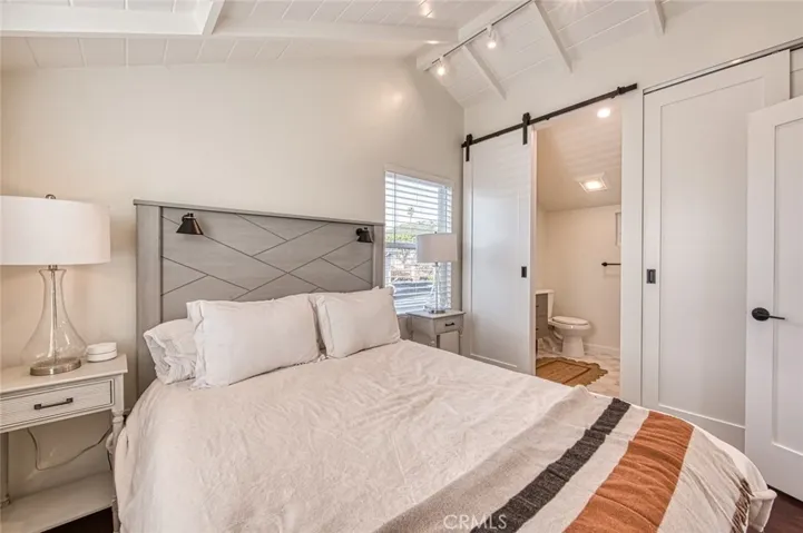 Furnished Bedroom with barn door into bathroom