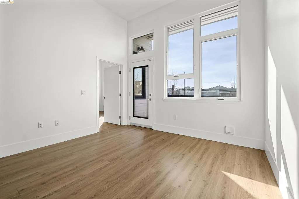 Empty room featuring light wood-style floors and a high ceiling