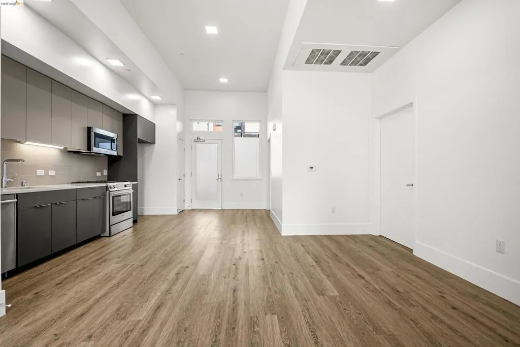 Kitchen featuring modern cabinets, gray cabinets, appliances with stainless steel finishes, and recessed lighting