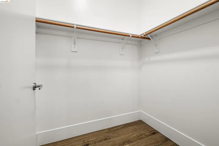 Walk in closet featuring dark wood-style flooring