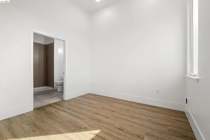 Spare room with light wood-style floors and a high ceiling