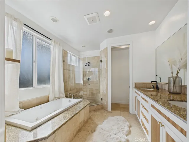 Primary suite bathroom with jacuzzi bathtub, dual vanity sinks. Walk in closet and second custom closet also are in this space.