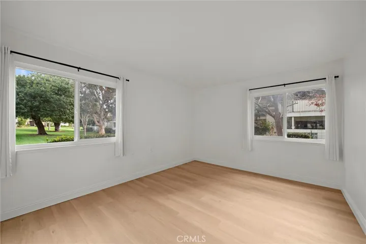 Primary Bedroom End unit with view of the greenbelt from window, new flooring, and window coverings.
