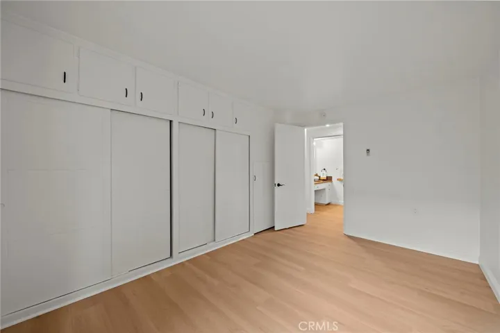 Another view of guest bedroom showing lots of closet space with upper storage.