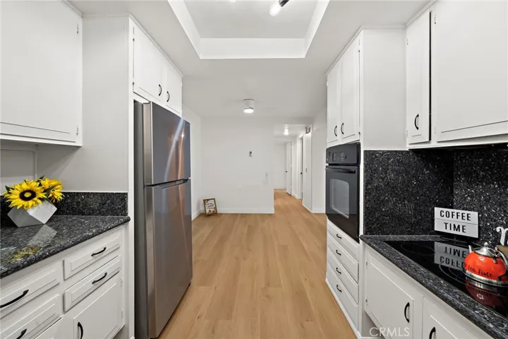 Another view of the beautiful updated kitchen showing the dining room and hall way to the bedrooms and bathrooms, and all new flooring throught.