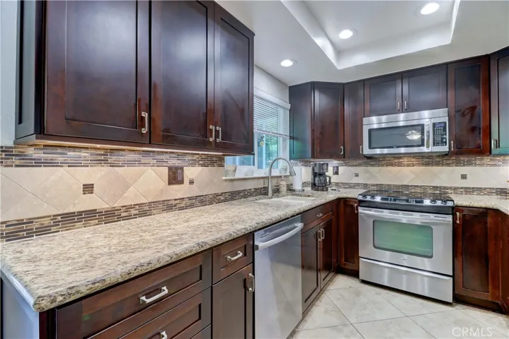 KITCHEN W S/S APPLIANCES & TRAY CEILING W RECESSED LIGHTING